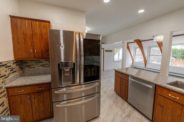 kitchen featuring light stone countertops, backsplash, and stainless steel appliances