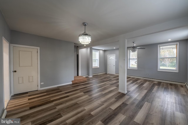 interior space with ceiling fan with notable chandelier, dark hardwood / wood-style flooring, and baseboard heating