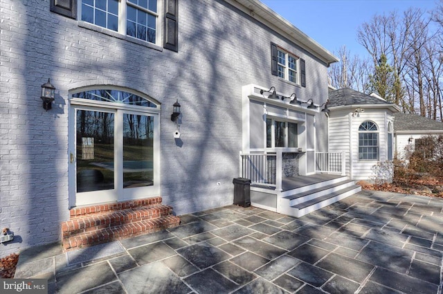 entrance to property with a patio and brick siding