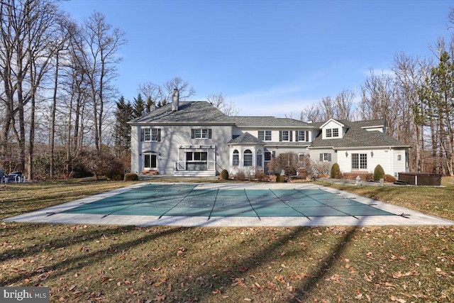 back of house featuring a covered pool, a patio, and a yard