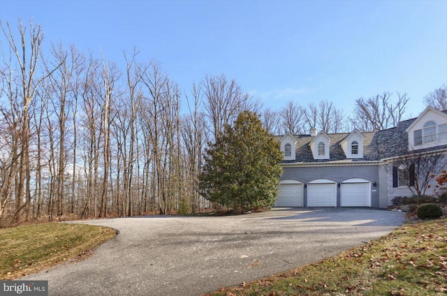 view of side of property with a garage and driveway