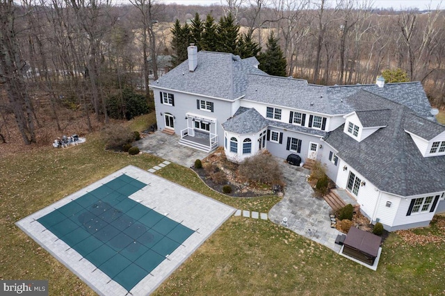 bird's eye view with a wooded view