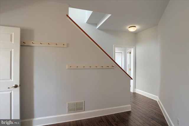 staircase featuring baseboards, visible vents, and wood finished floors