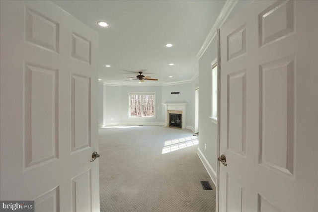 hallway with visible vents, baseboards, light colored carpet, ornamental molding, and recessed lighting