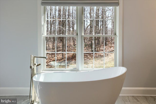 room details with a soaking tub and baseboards