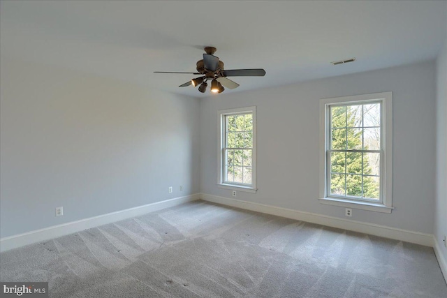 spare room featuring carpet, visible vents, ceiling fan, and baseboards