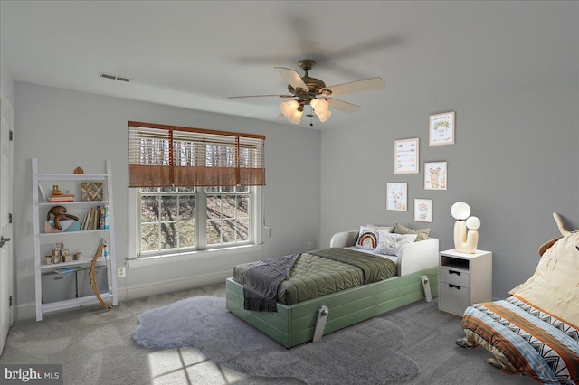 carpeted bedroom featuring a ceiling fan, visible vents, and baseboards