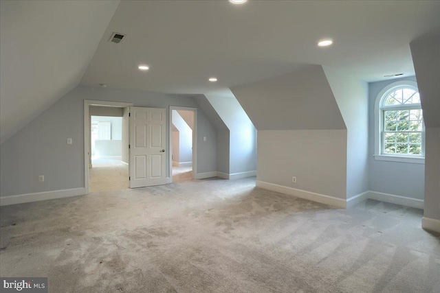 additional living space featuring recessed lighting, visible vents, light carpet, vaulted ceiling, and baseboards