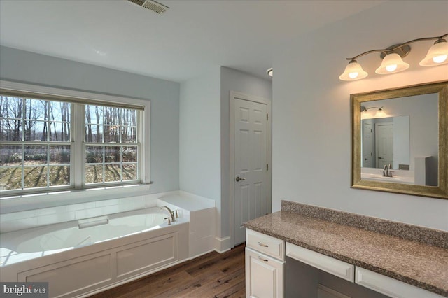 bathroom featuring vanity, wood finished floors, a garden tub, and visible vents