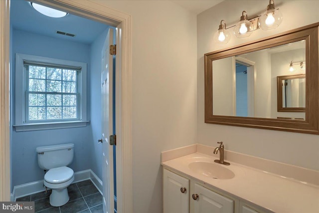 bathroom featuring tile patterned flooring, toilet, visible vents, vanity, and baseboards