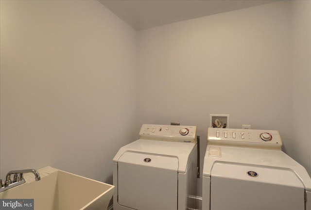 clothes washing area featuring washer and dryer, laundry area, and a sink