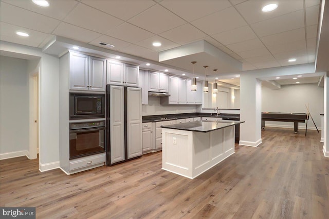 kitchen featuring dark countertops, visible vents, light wood-style flooring, and black appliances