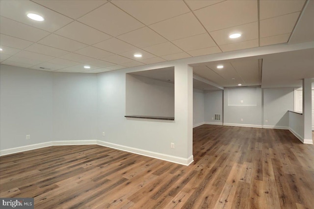 finished basement with dark wood-style floors, recessed lighting, visible vents, and baseboards