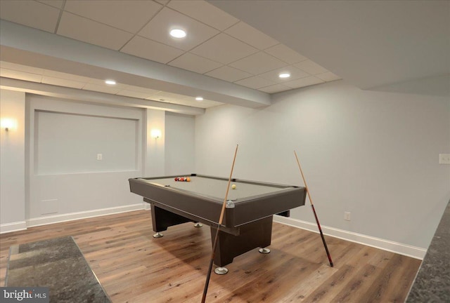 recreation room with wood finished floors, a paneled ceiling, and baseboards