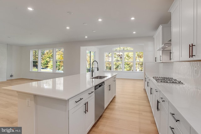 kitchen with a healthy amount of sunlight, sink, a large island with sink, and stainless steel appliances