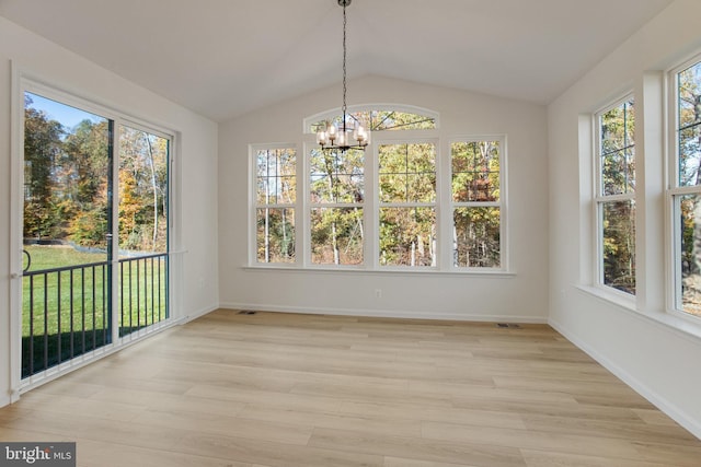 unfurnished sunroom featuring a healthy amount of sunlight, lofted ceiling, and an inviting chandelier