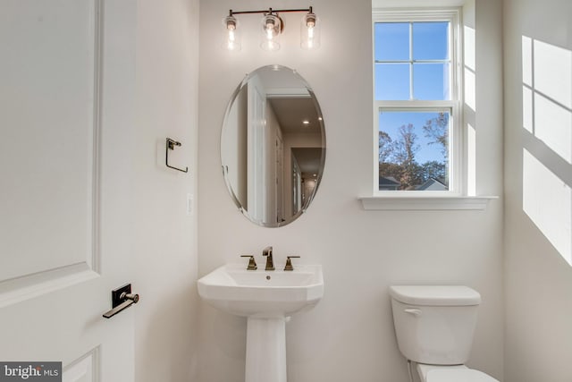 bathroom with toilet and a healthy amount of sunlight