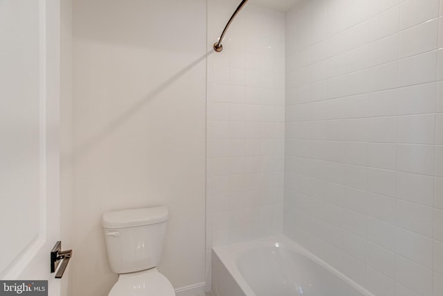 bathroom featuring tiled shower / bath combo and toilet