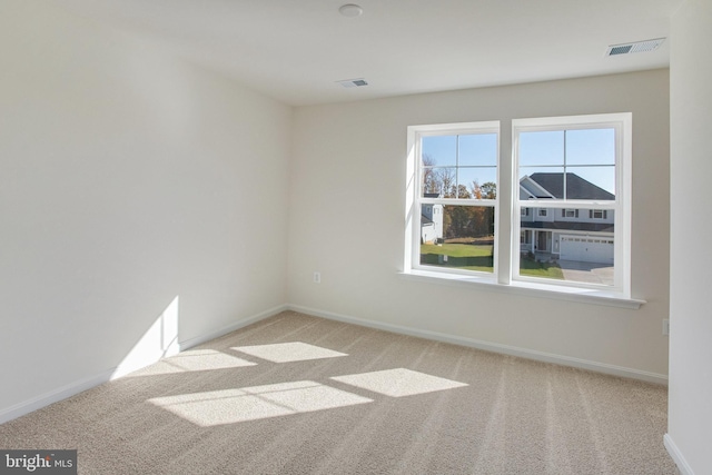 unfurnished room featuring light carpet