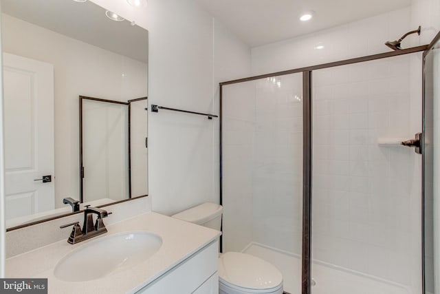 bathroom with vanity, a shower with shower door, and toilet