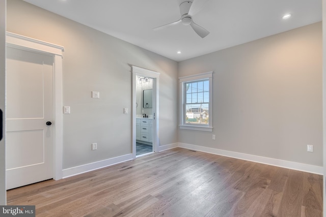 unfurnished bedroom with light wood-type flooring, ensuite bath, and ceiling fan