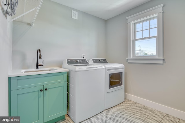 laundry room featuring cabinets, independent washer and dryer, and sink