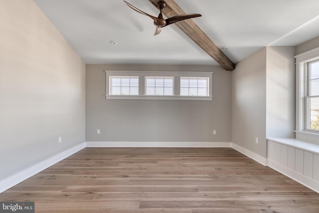 empty room featuring beam ceiling, light hardwood / wood-style floors, and ceiling fan