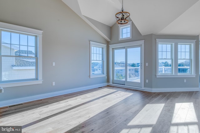 interior space with light hardwood / wood-style floors, high vaulted ceiling, and an inviting chandelier