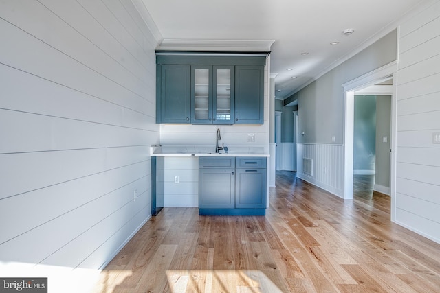 kitchen with crown molding, sink, and light hardwood / wood-style flooring