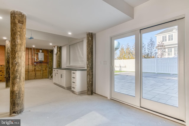 doorway to outside with tankless water heater and a wealth of natural light