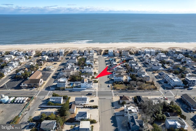 bird's eye view featuring a water view and a beach view