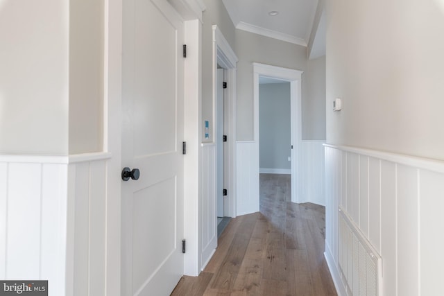 hallway featuring light wood-type flooring and crown molding