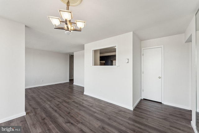 unfurnished living room featuring dark hardwood / wood-style flooring and an inviting chandelier