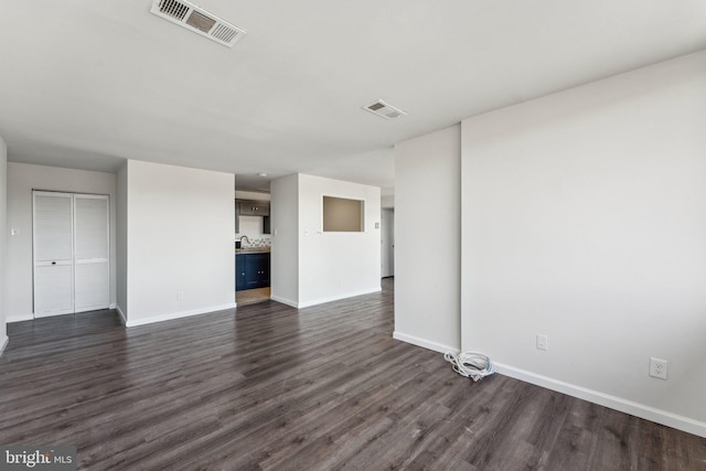 unfurnished living room with dark hardwood / wood-style floors and sink