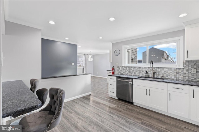 kitchen featuring sink, white cabinetry, tasteful backsplash, ornamental molding, and dishwasher