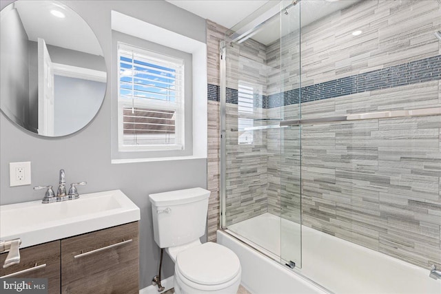 full bathroom with shower / bath combination with glass door, vanity, and toilet