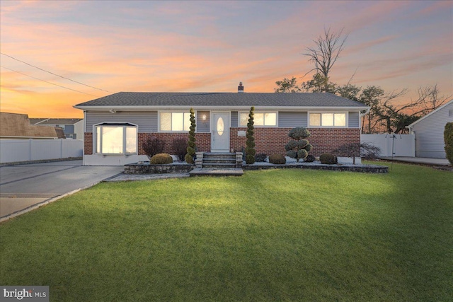 single story home with a garage and a lawn