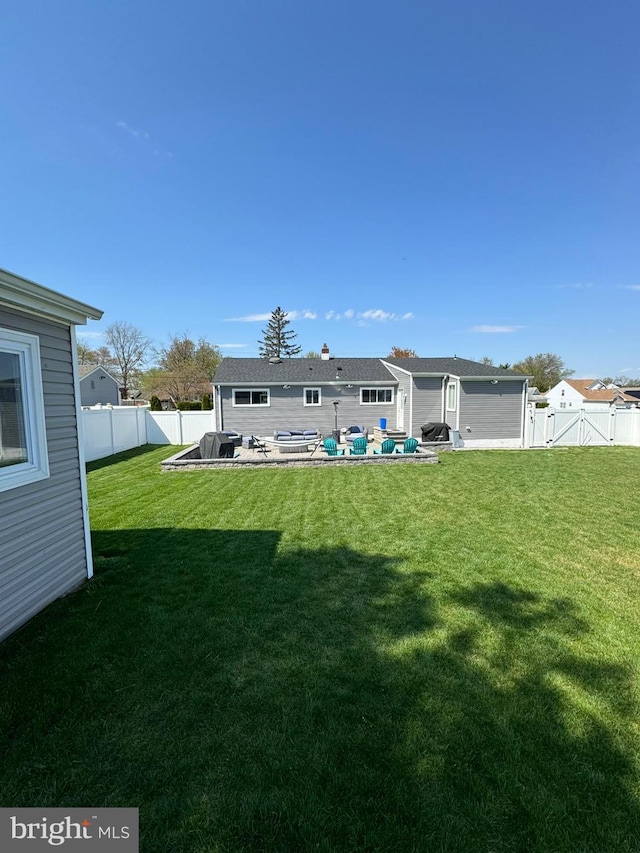 back of property with a yard and a patio