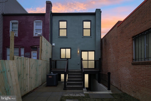 back house at dusk with central air condition unit