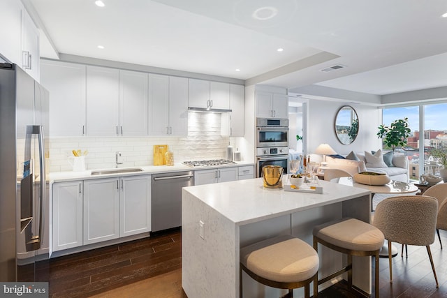 kitchen with white cabinets, appliances with stainless steel finishes, dark wood-type flooring, and sink