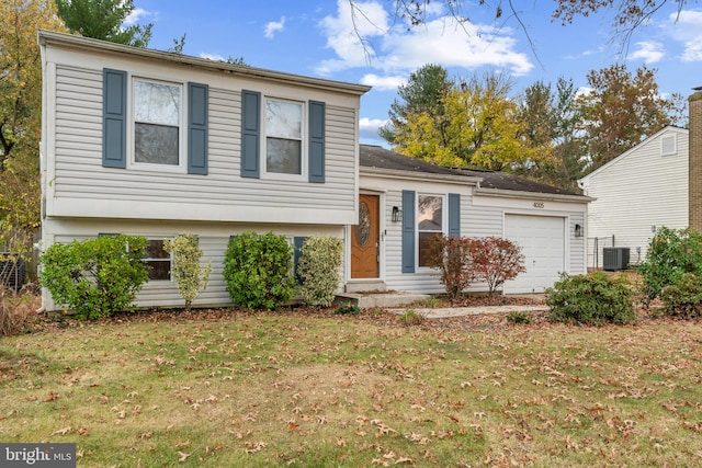 view of front facade featuring a front yard, a garage, and central AC unit