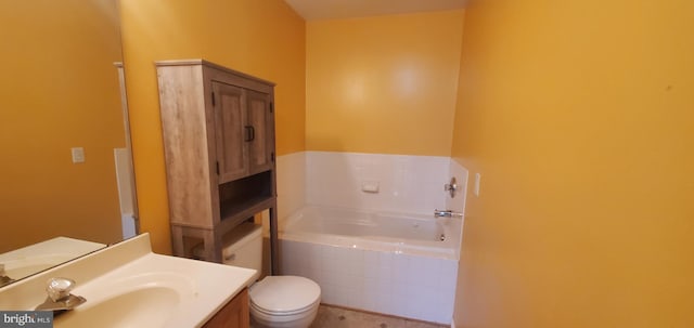 bathroom with a relaxing tiled tub, toilet, and vanity