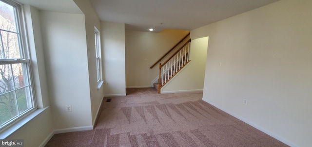 empty room featuring plenty of natural light and light carpet