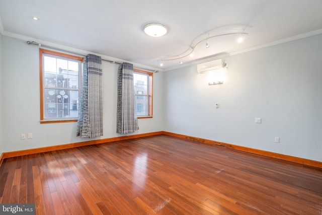 unfurnished room with wood-type flooring, an AC wall unit, and crown molding