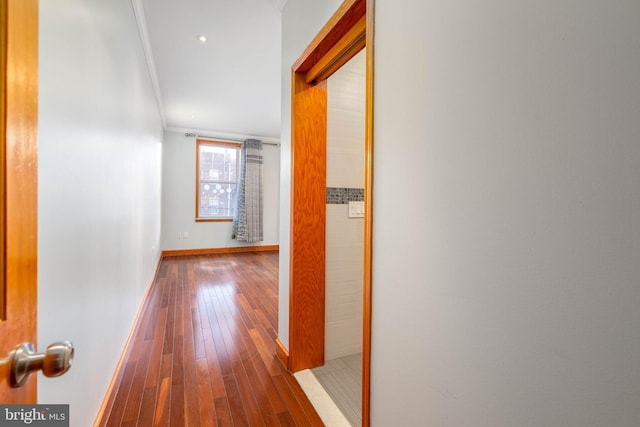 hall with wood-type flooring and ornamental molding