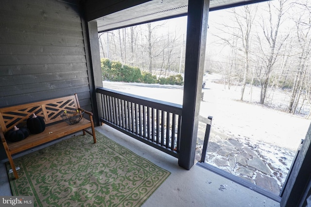 snow covered deck featuring a porch