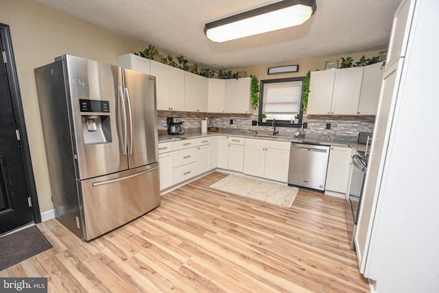 kitchen featuring sink, white cabinets, stainless steel appliances, and light hardwood / wood-style flooring