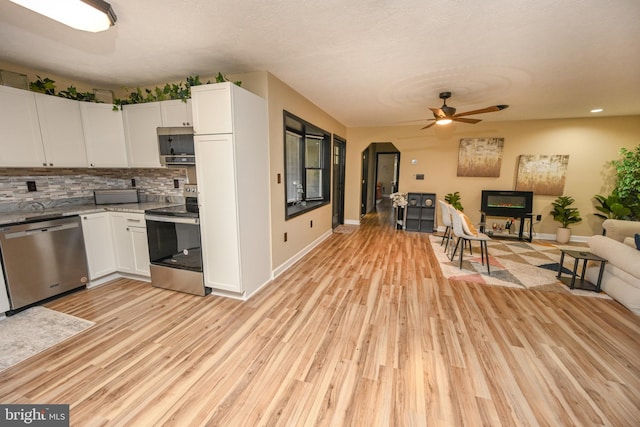 kitchen with appliances with stainless steel finishes, light hardwood / wood-style floors, white cabinetry, and ceiling fan