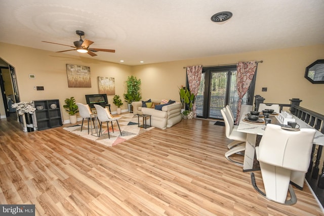 living room with light hardwood / wood-style flooring and ceiling fan