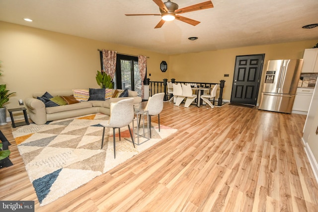 living room with ceiling fan and light hardwood / wood-style floors